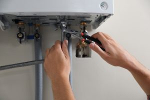 Man,Repairing,Gas,Boiler,With,Waterpump,Plier,,Closeup